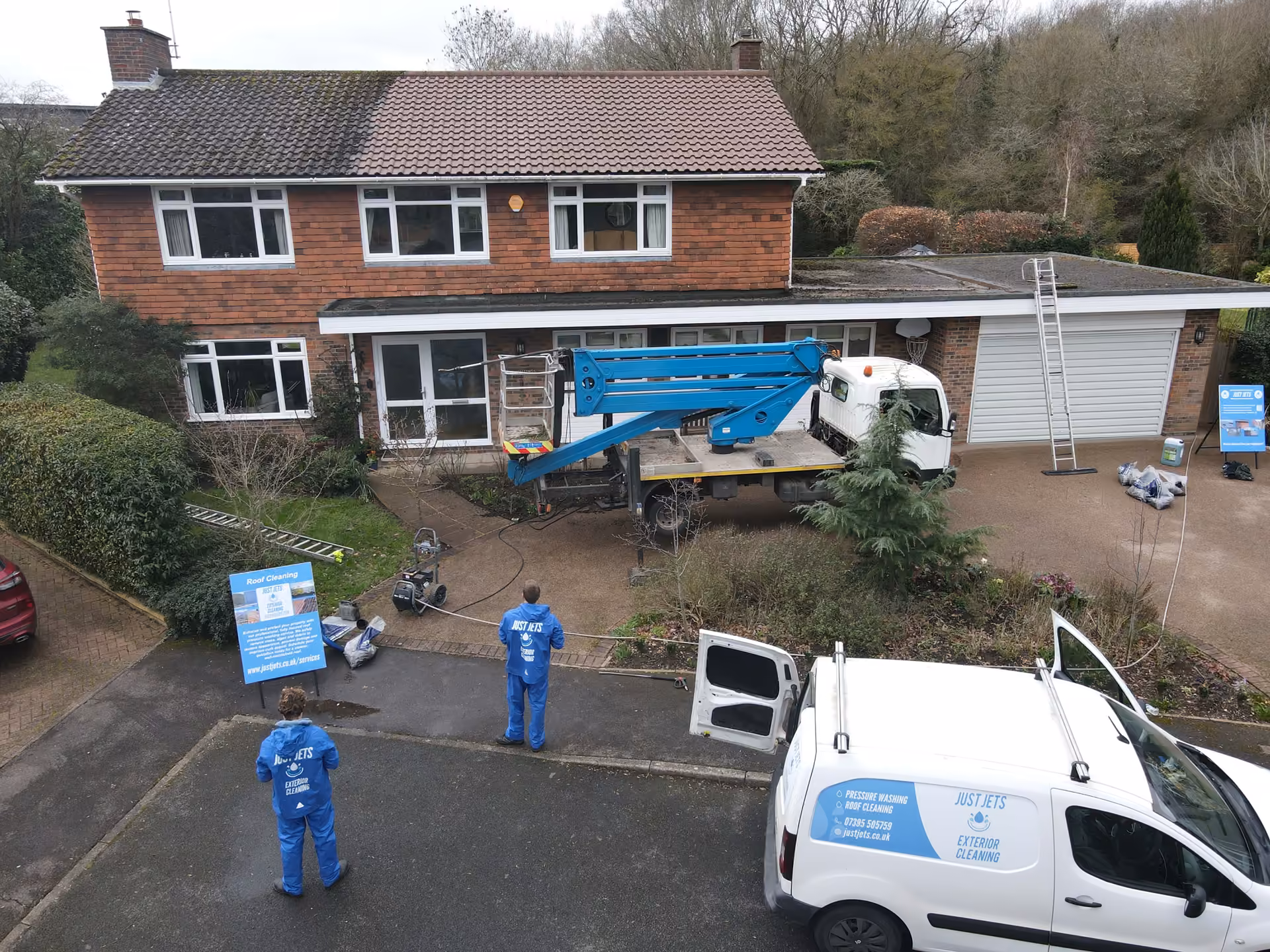Just Jets team mid-way through a roof clean in Essex, with the cleaned half of the roof next to the mossy half