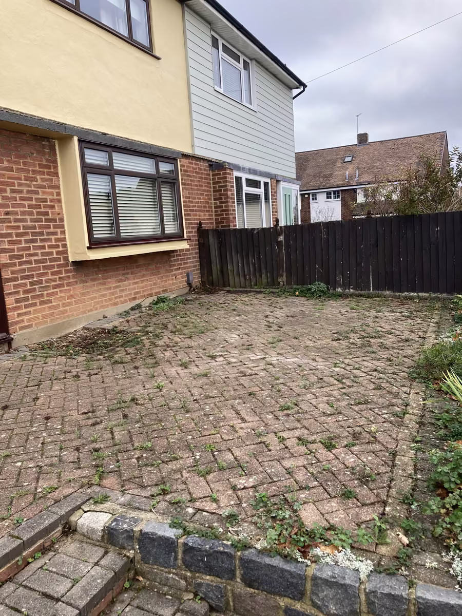 Block paving driveway covered in weeds, moss and dirt before cleaning